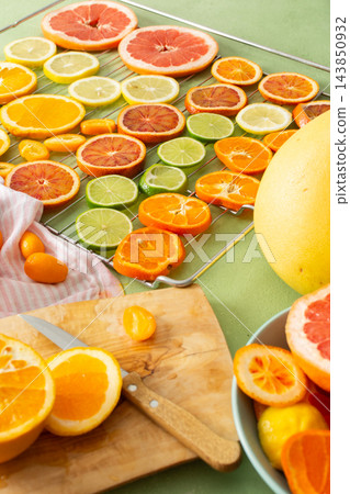 Citrus fruits are being prepared for Christmas drying. Different types of citrus are placed on a cutting board and drying rack in a home kitchen. The scene shows a festive activity Citrus fruits are being prepared for Christmas drying. Different types of citrus are placed on a cutting board and drying rack in a home kitchen. The scene shows a festive activity 143850932