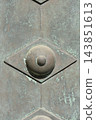 Decorative metal rivet on weathered bronze door texture 143851613