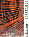 Orange plastic safety mesh fence at a construction site 143851614