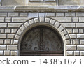 Historic building facade with stone arch and wrought iron gate detail 143851623