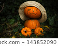 Man made from pumpkins in straw hat sits on ivy leaves 143852090
