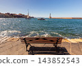 Empty Seaside Bench Overlooking Venetian Lighthouse and Harbor in Chania Crete Greece 143852543