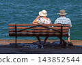 Senior Couple Sitting on Bench Overlooking the Sea in Chania Crete Greece 143852544