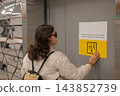 A blind woman reads an inscription on a door in Braille. 143852739