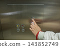 A blind woman presses a button with Braille in an elevator. 143852749