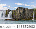 Godafoss waterfall and rugged basalt cliffs above turquoise water in Iceland 143852982