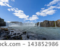 Godafoss waterfall from a low rocky riverbank under summer skies in Iceland 143852986