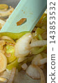 Spatula resting among sliced onions and green peppers in a pan 143853532