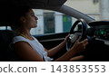 Woman driving a car with both hands on the steering wheel 143853553