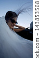Smiling bride in a white veil beside a car seat 143853568