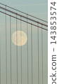 Close vertical view of the moon behind suspension bridge cables 143853574