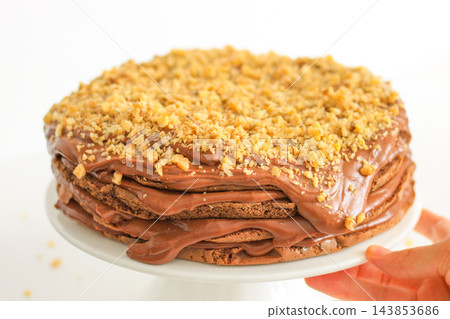 Homemade chocolate cake with nuts served on a plate close up Homemade chocolate cake with nuts served on a plate close up 143853686