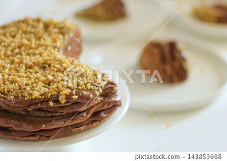 Homemade chocolate cake with nuts served on a plate close up Homemade chocolate cake with nuts served on a plate close up 143853698