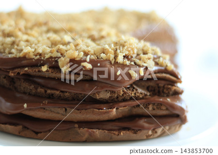 Homemade chocolate cake with nuts served on a plate close up Homemade chocolate cake with nuts served on a plate close up 143853700