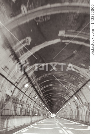 一條設有混凝土拱頂和持續照明的公路隧道。 一條設有混凝土拱頂和持續照明的公路隧道。 143853806