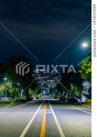 一張背景圖片，展現了一條安靜而緊張的夜間道路。 143853999