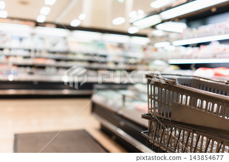 購物籃,背景是超市的食品區。 購物籃,背景是超市的食品區。 143854677