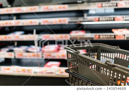 購物籃,背景是超市的食品區。 購物籃,背景是超市的食品區。 143854689