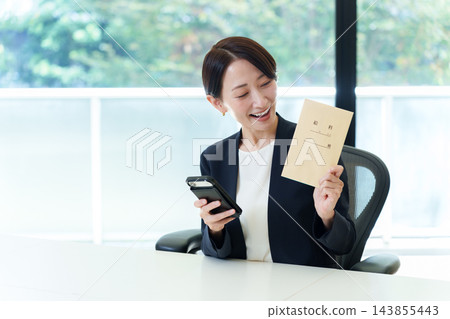 一位女商人拿著她的薪水信封 一位女商人拿著她的薪水信封 143855443