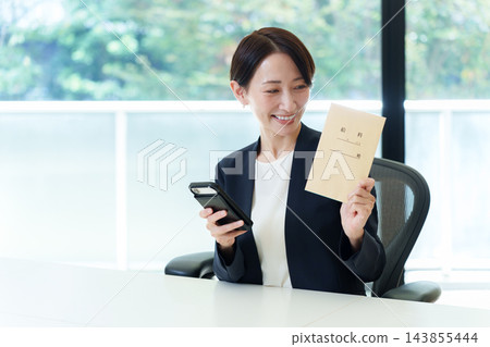 一位女商人拿著她的薪水信封 一位女商人拿著她的薪水信封 143855444