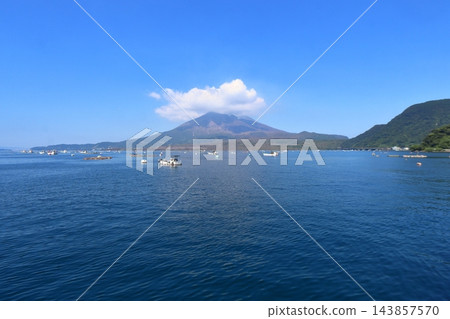 從垂水港(鹿兒島縣垂水市)看到的櫻島火山冒煙,漁船在港內穿梭。 從垂水港(鹿兒島縣垂水市)看到的櫻島火山冒煙,漁船在港內穿梭。 143857570