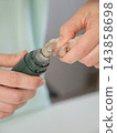 A veterinarian files a dog's nails with a grinder. Grooming salon. 143858698