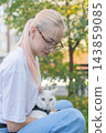 The owner puts the cat into a transparent carrier backpack. 143859085