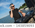 Male DJ playing music on the beach.  143859093