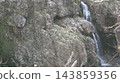 A small waterfall in a valley 143859356
