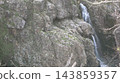 A small waterfall in a valley 143859357