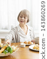 A senior woman's breakfast of freshly baked bread 143860269
