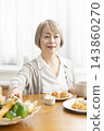 A senior woman's breakfast of freshly baked bread 143860270