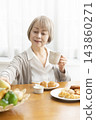 A senior woman's breakfast of freshly baked bread 143860271