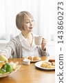 A senior woman's breakfast of freshly baked bread 143860273