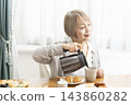 A senior woman's breakfast of freshly baked bread 143860282