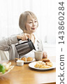 A senior woman's breakfast of freshly baked bread 143860284