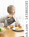 A senior woman's breakfast of freshly baked bread 143860285