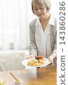 A senior woman's breakfast of freshly baked bread 143860286