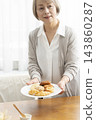 A senior woman's breakfast of freshly baked bread 143860287