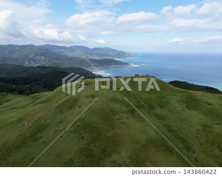 日本九州宮崎縣的東井岬:以其太平洋海岸線和燈塔而聞名,該岬角是日本本土馬種——岬馬的家園,它們在草原上吃草。 日本九州宮崎縣的東井岬:以其太平洋海岸線和燈塔而聞名,該岬角是日本本土馬種——岬馬的家園,它們在草原上吃草。 143860422