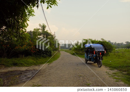 一輛三輪計程車行駛在尼泊爾藍毘尼的鄉村。 一輛三輪計程車行駛在尼泊爾藍毘尼的鄉村。 143860850
