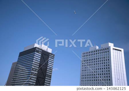一架飛機飛越新宿西口的摩天大樓，前往羽田機場。 143862125