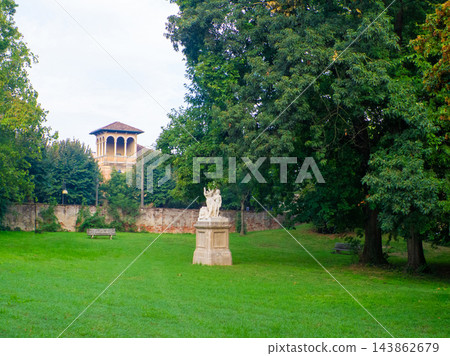 Green park lawn with a white marble statue on a pedestal in the center Green park lawn with a white marble statue on a pedestal in the center 143862679