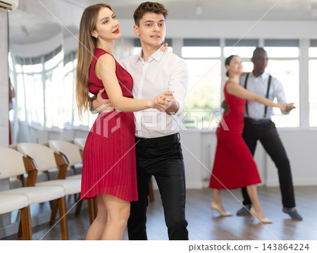 Young man and girl dancing waltz in couple during lesson at studio Young man and girl dancing waltz in couple during lesson at studio 143864224