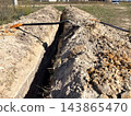 a trench excavated using a shovel at a construction site. Trench for laying pipes 143865470