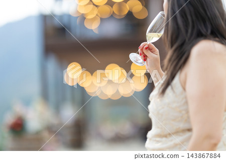 Woman raising a glass of sparkling wine at an elegant celebration Woman raising a glass of sparkling wine at an elegant celebration 143867884