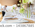 Wedding reception table setting with green floral centerpieces 143867885