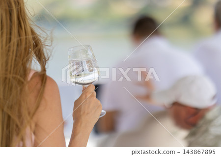 Woman holding a sparkling wine glass during outdoor dining Woman holding a sparkling wine glass during outdoor dining 143867895