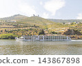 River cruise ship sailing past terraced vineyards in portugal's douro valley 143867898