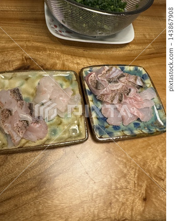 生魚片盛放在兩個盤子裡。 生魚片盛放在兩個盤子裡。 143867908